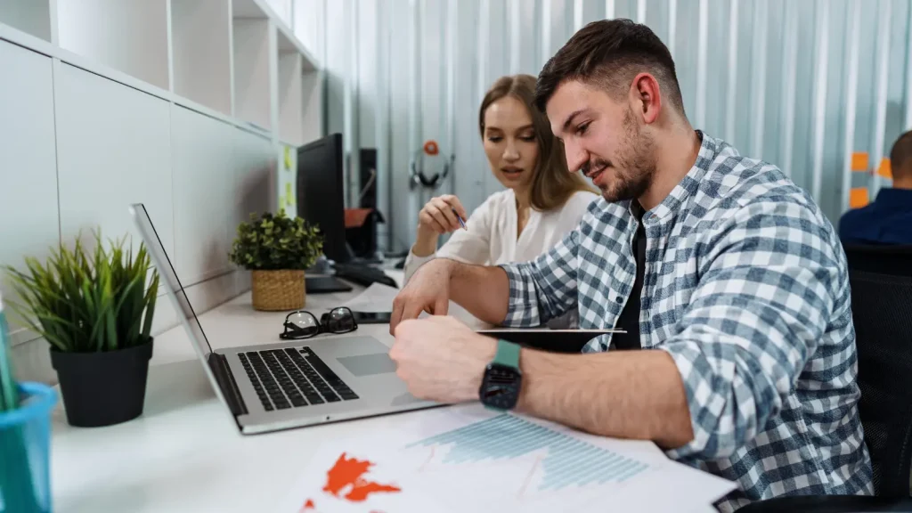 Two people working at a laptop