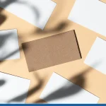 Blank white business card on beige background with creative floral shadow