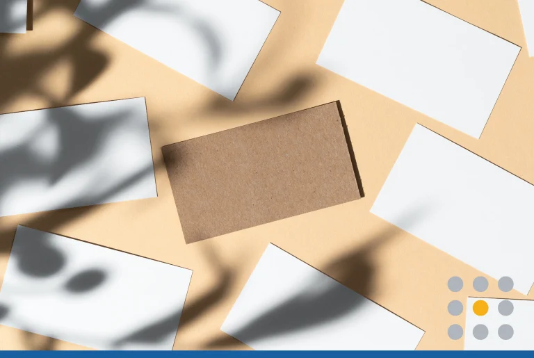 Blank white business card on beige background with creative floral shadow