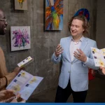 Happy artist interacting with guests of exhibition of his artworks