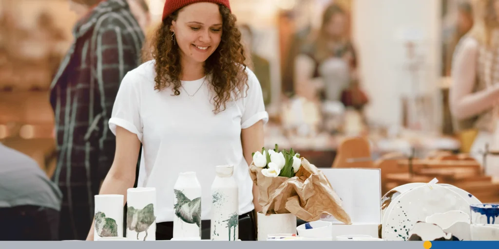 Girl selling handmade ceramics market counter
