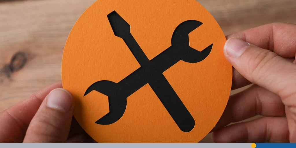 Closeup shot of a man holding an orange and black instruments icon on a wooden background
