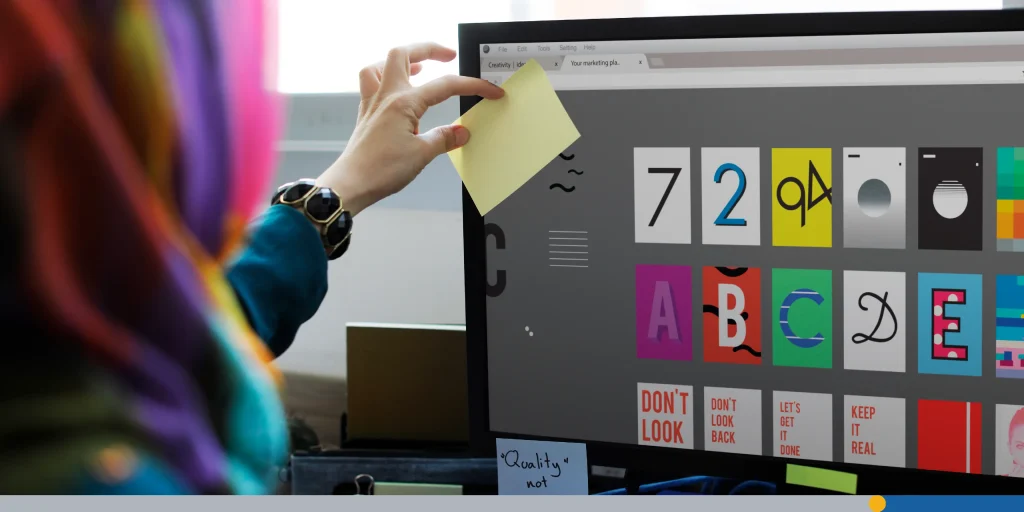 Designer choosing a font on a desktop computer