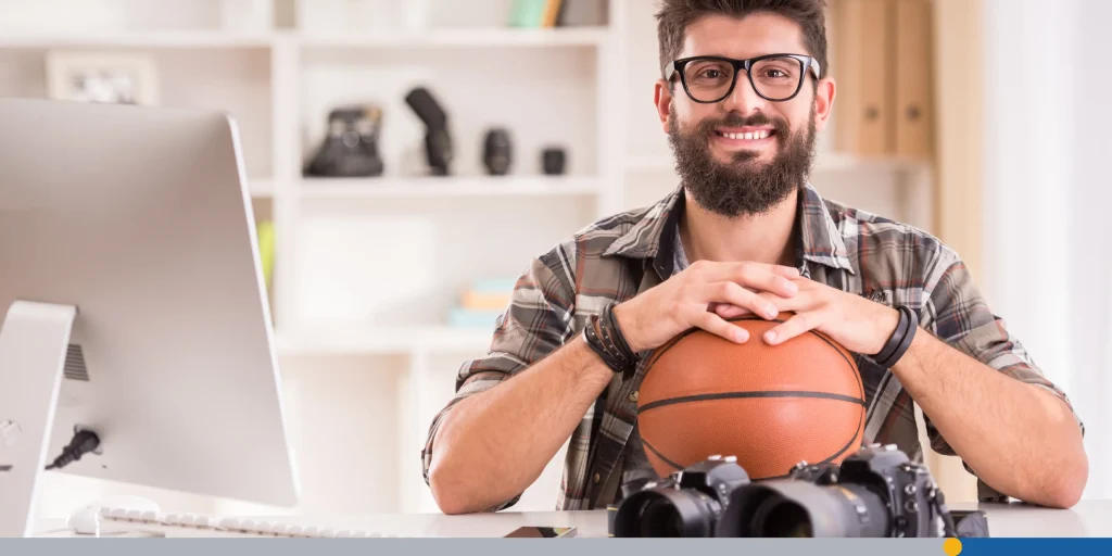 Bearded man smiling at the camera with a basketball