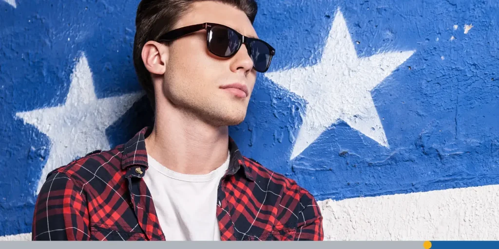 Handsome male model in checked shirt posing against background.