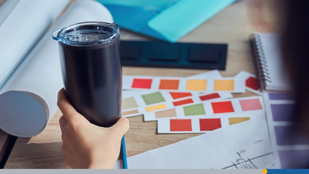 Rear view of interior designer holding bottle while working on a project with color samples
