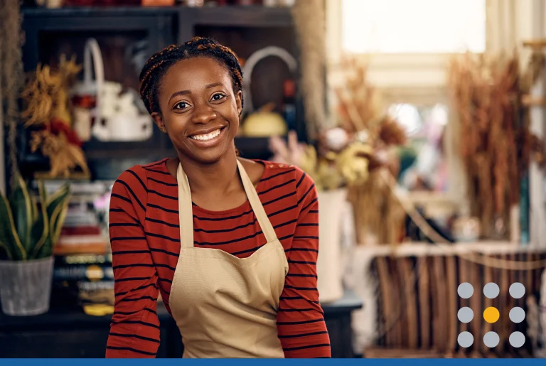 Woman working as florist at flower shop and looking at camera