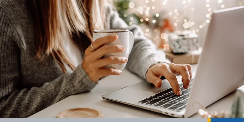 Woman with mug typing at laptop