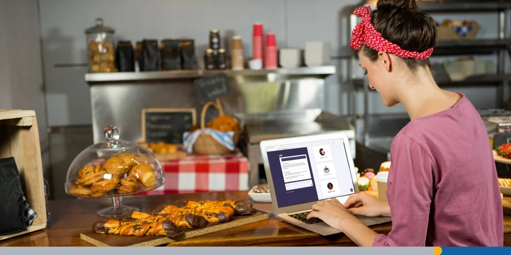 Woman using laptop at bakery counter