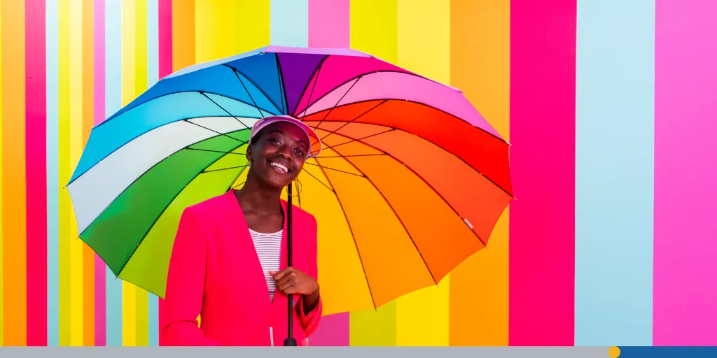 Beautiful young woman dancing and having fun inside a rainbow box room