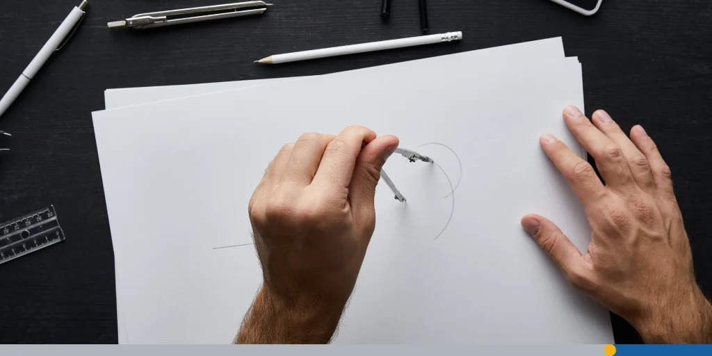 Man drawing circle on paper with compass
