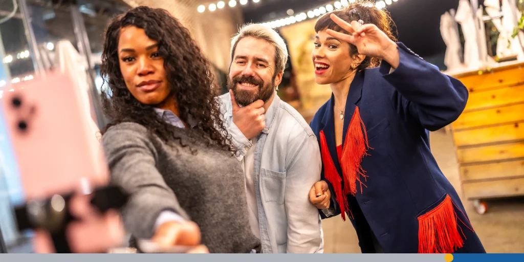 Friends gesturing success while streaming online video at night outdoors