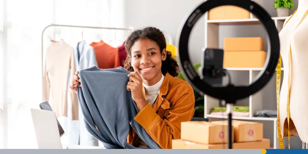 Woman designer entrepreneur showing clothes product on live online social media streaming 