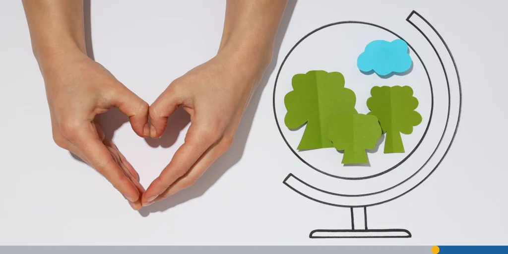 Hands making a heart shape next to a animated globe