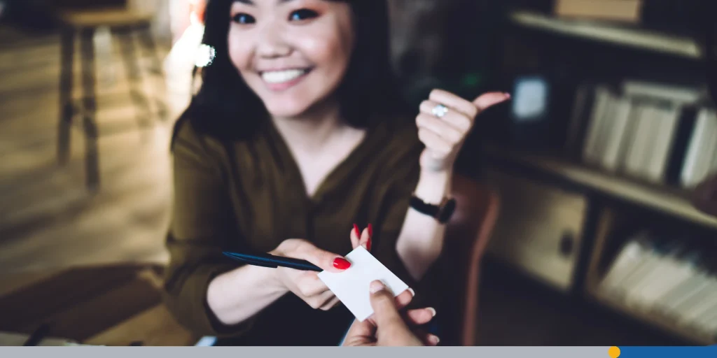 Smiling woman giving business card to woman