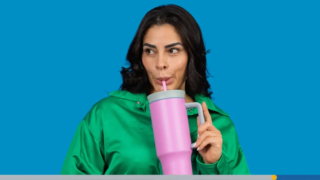 Woman drinking from a pink travel cup