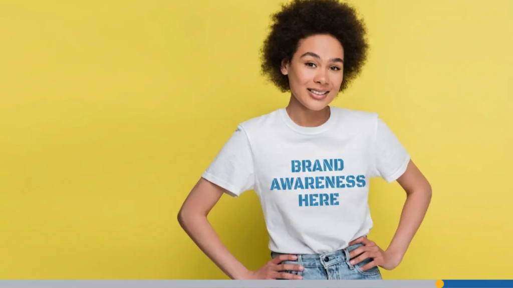 A young woman wears a T-shirt with the words brand awareness here printed across it, representing corporate gift ideas.