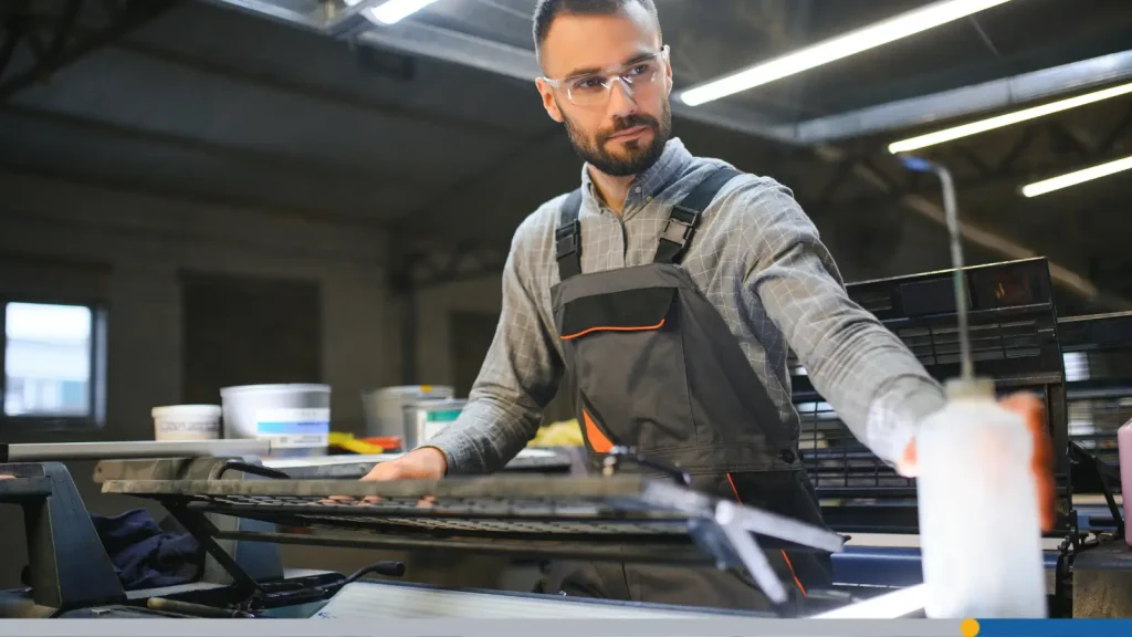 Man working with screen printing machine