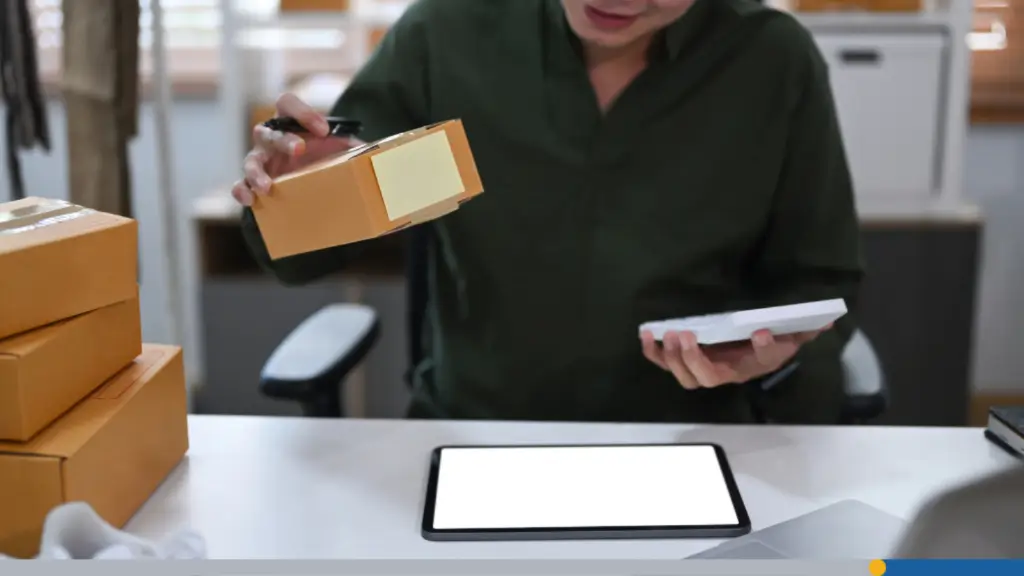 Someone uses a tablet computer to check the order they received, including several boxes of materials to build business cards.