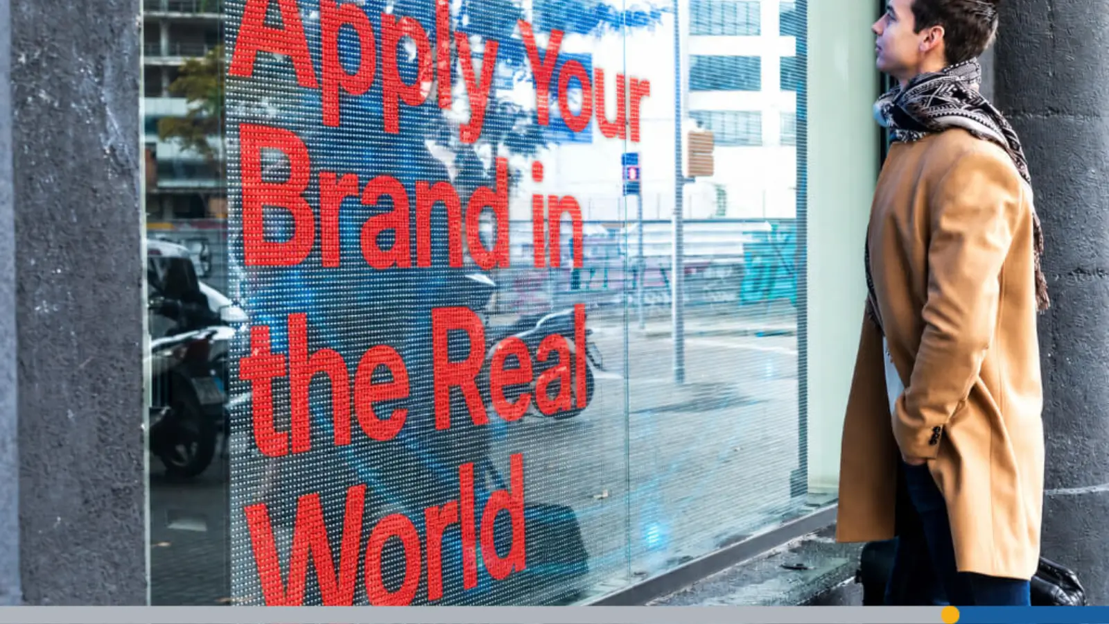 A young man looking into a store window featuring custom brands.