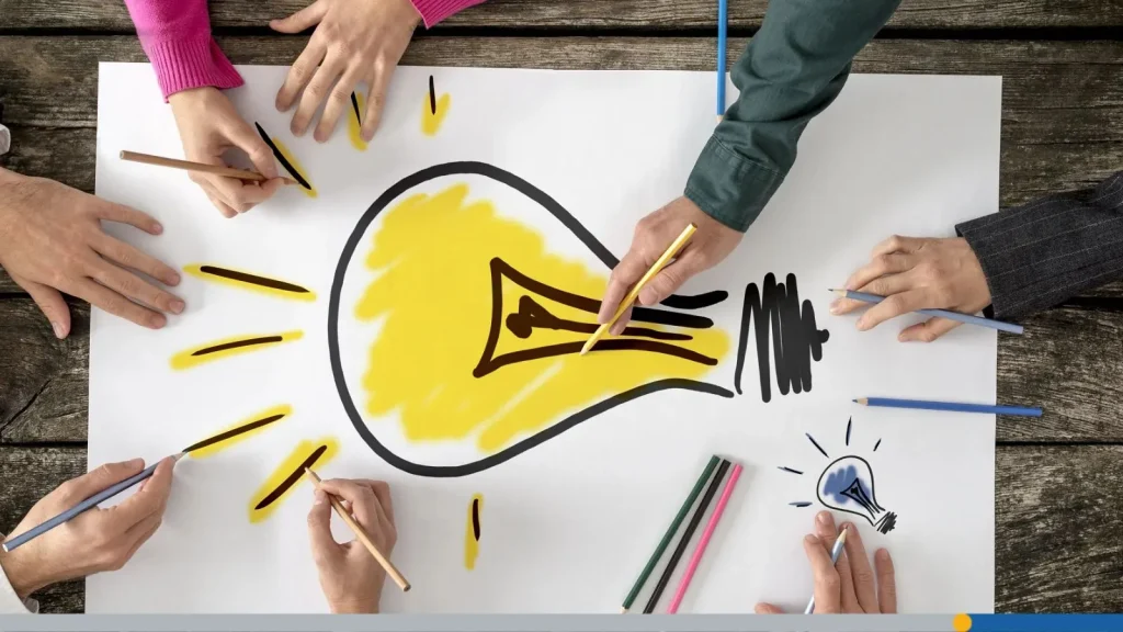 Business idea with a lit light bulb on a big piece of paper.