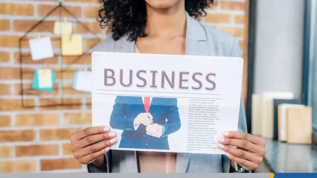 Woman holding a piece of paper with the word BUSINESS written on it, signaling the ways you can create your own business.