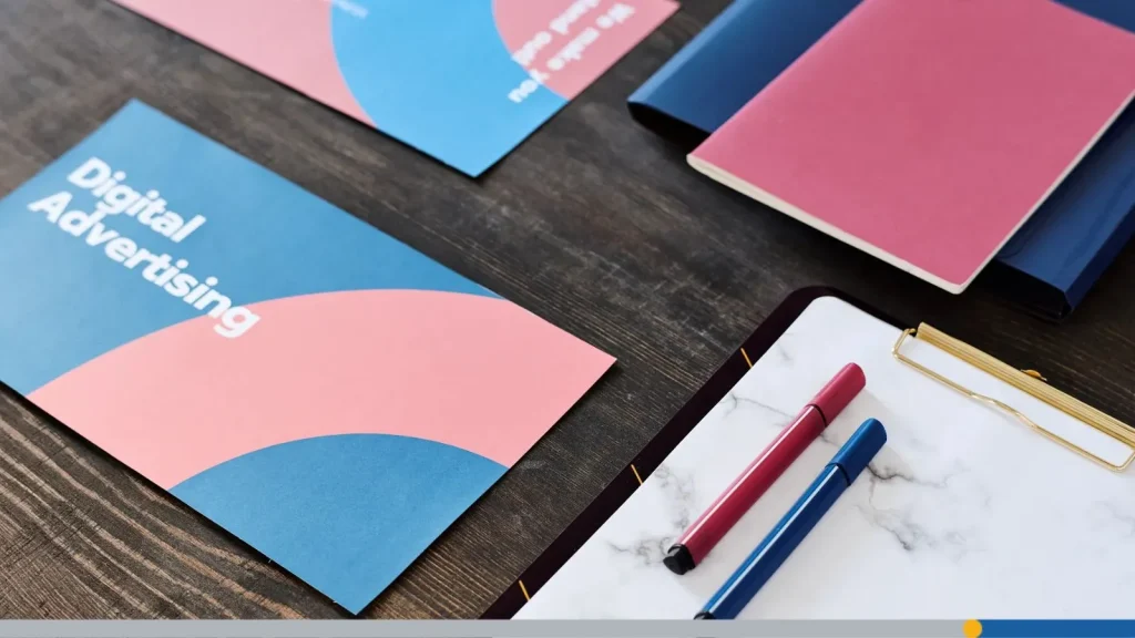 Business cards on a wooden office table, with a notepad and a few pens.