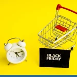 Shopping cart and alarm clock beside a Black Friday bag