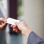 Woman handing business card to another woman