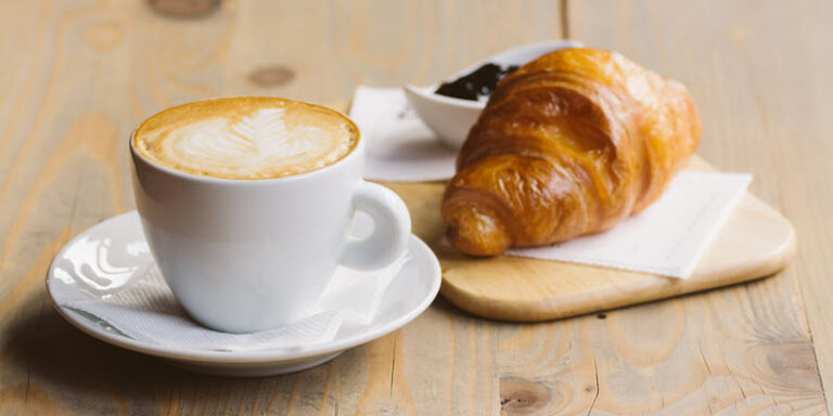 Latte and croissant on table