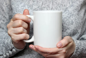 girl holding white coffee mug