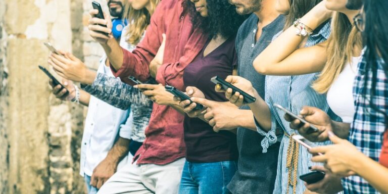 a group of young adults all on their cell phones