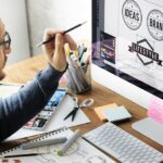 Designer on the computer using brand guidelines to create an on-brand logo for a company