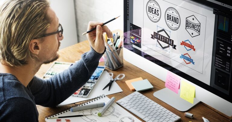 Designer on the computer using brand guidelines to create an on-brand logo for a company