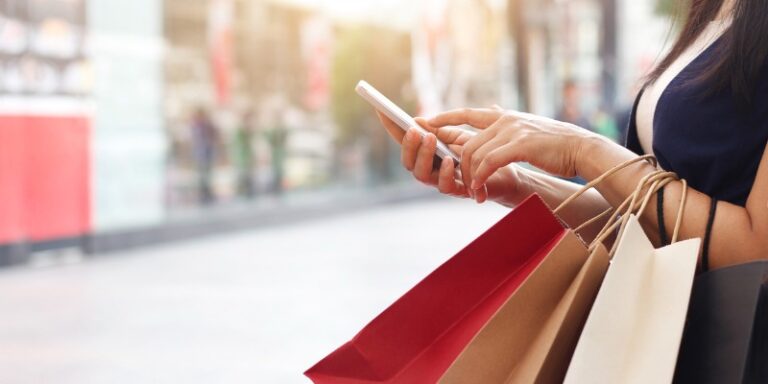 woman on her cell phone holding shopping bags